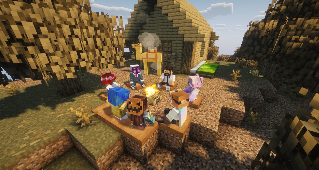 Players gathered around a campfire beside a cozy building in FoxVale